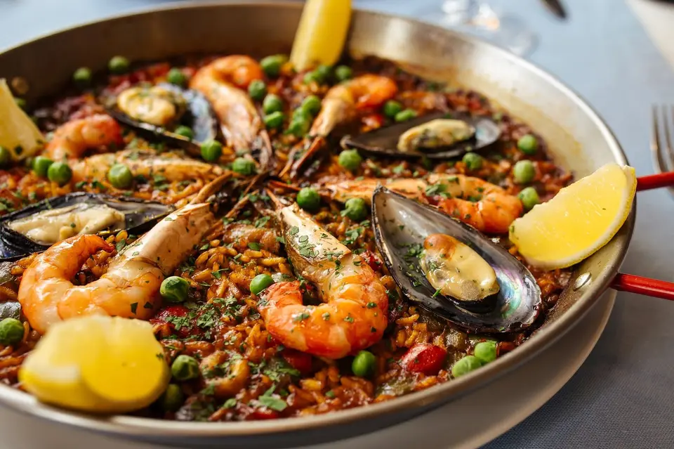 Paella di pesce con gamberoni, cozze e limone